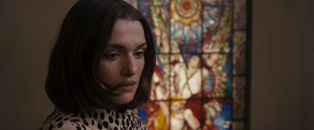Movie still from “The Brothers Bloom” (2008), directed by Rian Johnson – A woman in front of a stained - glass window; Close Up shot, Low angle