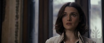 Movie still from “The Brothers Bloom” (2008), directed by Rian Johnson – A person wearing a white jacket; Close Up shot, Over the shoulder angle