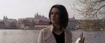 Movie still from “The Brothers Bloom” (2008), directed by Rian Johnson – A woman standing in front of a body of water; Close Up shot, Over the shoulder angle