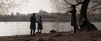 Movie still from “The Brothers Bloom” (2008), directed by Rian Johnson – Two people standing on the bank of a river; Wide shot, Over the shoulder angle