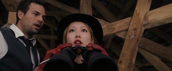 Movie still from “The Brothers Bloom” (2008), directed by Rian Johnson – A woman with red gloves and a black hat; Close Up shot, Low angle