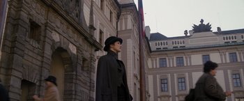 Movie still from “The Brothers Bloom” (2008), directed by Rian Johnson – A man in a top hat stands in front of a building; Wide shot, Low angle
