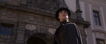 Movie still from “The Brothers Bloom” (2008), directed by Rian Johnson – A woman wearing a black hat and a black coat; Medium shot, Low angle