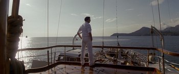 Movie still from “The Brothers Bloom” (2008), directed by Rian Johnson – A man standing on the deck of a boat in the ocean; Wide shot, Low angle