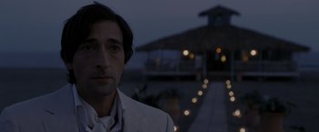 Movie still from “The Brothers Bloom” (2008), directed by Rian Johnson – A person wearing a suit and tie; Close Up shot, Over the shoulder angle