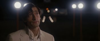 Movie still from “The Brothers Bloom” (2008), directed by Rian Johnson – A person wearing a suit and tie; Close Up shot, Over the shoulder angle
