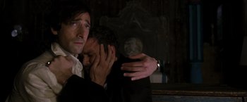 Movie still from “The Brothers Bloom” (2008), directed by Rian Johnson – A man holding another man's face in a dark room; Close Up shot, High angle
