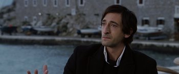 Movie still from “The Brothers Bloom” (2008), directed by Rian Johnson – A person wearing a suit and tie; Close Up shot, Over the shoulder angle