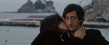 Movie still from “The Brothers Bloom” (2008), directed by Rian Johnson – A man and a woman kissing in front of a body of water; Close Up shot, Over the shoulder angle