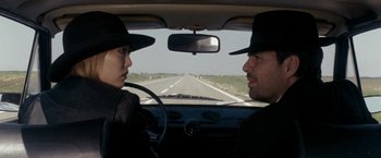 Movie still from “The Brothers Bloom” (2008), directed by Rian Johnson – Two people in a car on a road; Close Up shot, Over the shoulder angle