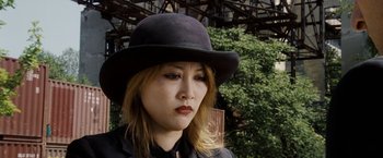 Movie still from “The Brothers Bloom” (2008), directed by Rian Johnson – A woman wearing a black hat and a black jacket; Close Up shot, Low angle