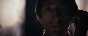 Movie still from “The Brothers Bloom” (2008), directed by Rian Johnson – A man's face in the dark; Close Up shot, Low angle