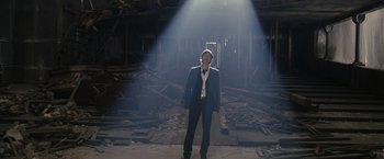 Movie still from “The Brothers Bloom” (2008), directed by Rian Johnson – A man in a suit standing in the middle of an abandoned building; Wide shot, Low angle