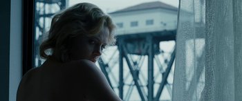 Movie still from “The Burning Plain” (2008), directed by Guillermo Arriaga – A woman with blonde curly hair looking out of a window; Close Up shot, Low angle