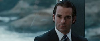 Movie still from “The Burning Plain” (2008), directed by Guillermo Arriaga – A person wearing a suit and tie; Close Up shot, Over the shoulder angle