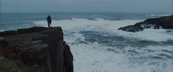 Movie still from “The Burning Plain” (2008), directed by Guillermo Arriaga – A man standing on a cliff next to a body of water; Extreme Wide shot, Low angle