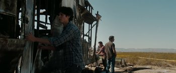 Movie still from “The Burning Plain” (2008), directed by Guillermo Arriaga – A group of people standing next to each other near a building; Medium shot, Over the shoulder angle