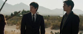 Movie still from “The Burning Plain” (2008), directed by Guillermo Arriaga – A man wearing a suit and tie standing in a field; Medium shot, Low angle