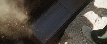 Movie still from “The Burning Plain” (2008), directed by Guillermo Arriaga – A wooden table sitting in the middle of a field; Extreme Close Up shot, Overhead angle