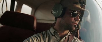 Movie still from “The Burning Plain” (2008), directed by Guillermo Arriaga – A man wearing headphones and glasses sitting in a vehicle; Close Up shot, Low angle