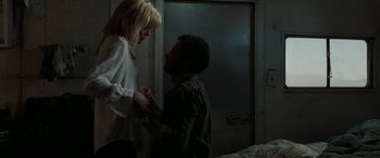 Movie still from “The Burning Plain” (2008), directed by Guillermo Arriaga – A man and a woman standing next to each other in front of a door; Medium shot, High angle