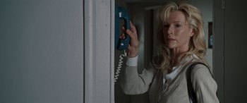 Movie still from “The Burning Plain” (2008), directed by Guillermo Arriaga – A woman holding a phone up to a wall; Close Up shot, Low angle