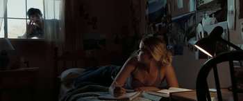 Movie still from “The Burning Plain” (2008), directed by Guillermo Arriaga – A woman laying on a bed writing on a piece of paper; Wide shot, High angle