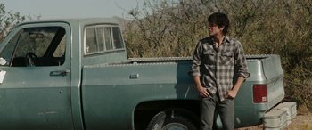 Movie still from “The Burning Plain” (2008), directed by Guillermo Arriaga – A man standing next to an old pick - up truck; Medium shot, Low angle