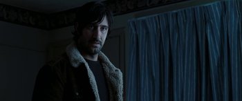 Movie still from “The Burning Plain” (2008), directed by Guillermo Arriaga – A man with a beard standing in front of a window; Close Up shot, Over the shoulder angle