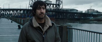 Movie still from “The Burning Plain” (2008), directed by Guillermo Arriaga – A man standing in front of a river; Medium shot, Over the shoulder angle