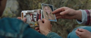 Movie still from “The Burning Plain” (2008), directed by Guillermo Arriaga – A person holding a picture of a woman and a man; Extreme Close Up shot, High angle