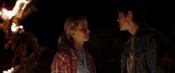 Movie still from “The Burning Plain” (2008), directed by Guillermo Arriaga – A young man and a young woman standing next to each other in the dark; Medium shot, Over the shoulder angle