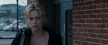 Movie still from “The Burning Plain” (2008), directed by Guillermo Arriaga – A woman standing in front of a brick building; Close Up shot, Over the shoulder angle