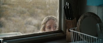 Movie still from “The Burning Plain” (2008), directed by Guillermo Arriaga – A woman looking out of a rainy window; Medium shot, Over the shoulder angle