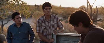 Movie still from “The Burning Plain” (2008), directed by Guillermo Arriaga – A young man standing next to a fence; Medium shot, Over the shoulder angle