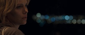 Movie still from “The Burning Plain” (2008), directed by Guillermo Arriaga – A person's face with lights in the background; Close Up shot, Over the shoulder angle