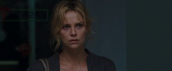 Movie still from “The Burning Plain” (2008), directed by Guillermo Arriaga – A woman is looking at the camera with a serious look on her face; Close Up shot, Over the shoulder angle