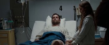 Movie still from “The Burning Plain” (2008), directed by Guillermo Arriaga – A man laying in a hospital bed in a hospital room; Medium shot, Overhead angle
