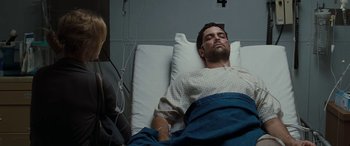 Movie still from “The Burning Plain” (2008), directed by Guillermo Arriaga – A man laying in a hospital bed next to a woman; Medium shot, High angle