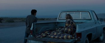 Movie still from “The Burning Plain” (2008), directed by Guillermo Arriaga – Two people sitting in the back of a pick - up truck; Wide shot, Over the shoulder angle