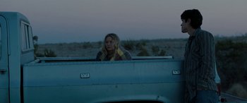 Movie still from “The Burning Plain” (2008), directed by Guillermo Arriaga – A woman sitting in the back of a pick - up truck; Wide shot, Over the shoulder angle