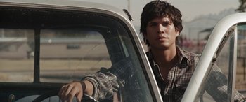 Movie still from “The Burning Plain” (2008), directed by Guillermo Arriaga – A young man sitting in the driver's seat of a car; Close Up shot, Over the shoulder angle