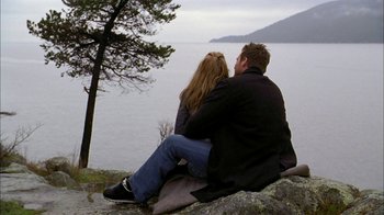 Movie still from “The Butterfly Effect 2” (2006), directed by John R. Leonetti – A man and a woman sitting on top of a rock near a body of water; Wide shot, High angle