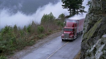 Movie still from “The Butterfly Effect 2” (2006), directed by John R. Leonetti – A large red truck driving down a road; Extreme Wide shot, High angle