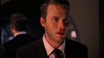 Movie still from “The Butterfly Effect 2” (2006), directed by John R. Leonetti – A man in a black suit and red tie; Close Up shot, Over the shoulder angle