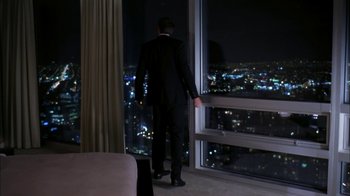 Movie still from “The Butterfly Effect 2” (2006), directed by John R. Leonetti – A man in a suit looking out of a window at night; Wide shot, High angle