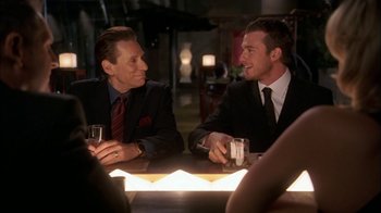 Movie still from “The Butterfly Effect 2” (2006), directed by John R. Leonetti – A couple of men sitting at a table with drinks; Medium shot, Over the shoulder angle