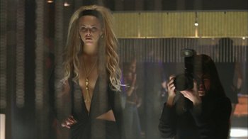 Movie still from “The Butterfly Effect 2” (2006), directed by John R. Leonetti – A woman in a black dress is posing for a picture; Medium shot, Low angle