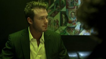 Movie still from “The Butterfly Effect 2” (2006), directed by John R. Leonetti – A man in a green suit and yellow shirt; Close Up shot, Over the shoulder angle