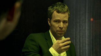 Movie still from “The Butterfly Effect 2” (2006), directed by John R. Leonetti – A person wearing a suit holding a cell phone; Close Up shot, Over the shoulder angle